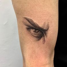 an eye with tear coming out of it's irise is shown on the leg