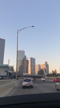 cars are driving down the highway in front of tall buildings