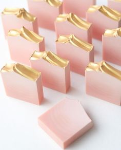 small pink and gold squares are arranged on a white surface