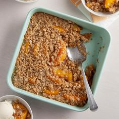 a bowl of peach crisp with two bowls of ice cream