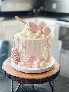 a pink and white cake sitting on top of a table