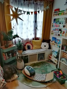 a room filled with lots of toys and books on the floor next to a window