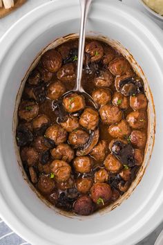 a white bowl filled with meatballs and mushrooms