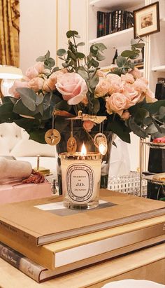 a vase filled with pink roses sitting on top of a table next to a book