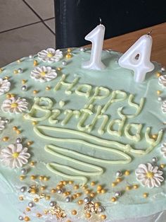 a green birthday cake with white frosting and flowers