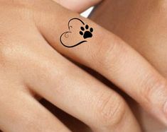 a woman's hand with a dog paw tattoo on it