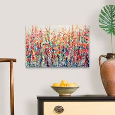 a painting is hanging on the wall next to a bowl of lemons and a potted plant