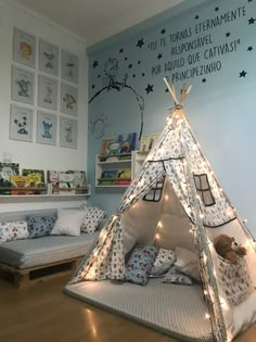 a child's bedroom with a teepee tent and pillows