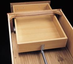 an empty wooden box with spoons in it