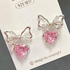 Pink Crystal Bowknot Heart Dangle Earrings These adorable Pink Crystal Bowknot Heart Dangle Earrings are the perfect accessory for any fashion-forward person. Made with high-quality materials and adorned with pink crystals, these earrings will add a touch of sweet charm to any outfit. The heart-shaped design and delicate bowknot detail make these earrings simply irresistible. Pretty Earrings Aesthetic, Heart Dangle Earrings, Classy Jewelry, Fancy Jewelry