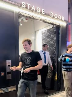 two men standing in front of a stage door