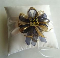 a white pillow with a black and gold ribbon on it