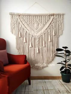 a red chair sitting in front of a wall hanging