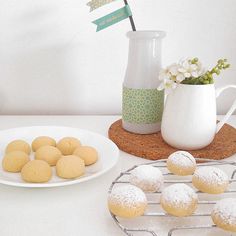 some cookies are sitting on a plate next to a vase with flowers