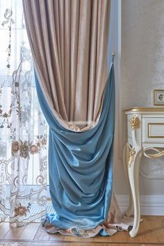 the curtains in this room are drapes with blue and beige color blocking them off