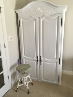 a white armoire sitting in the corner of a room