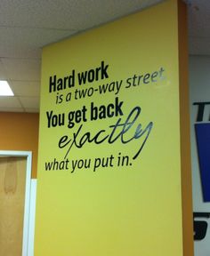 a sign that is on the side of a wall in an office building saying hard work is a two - way street you get back exactly what you put in