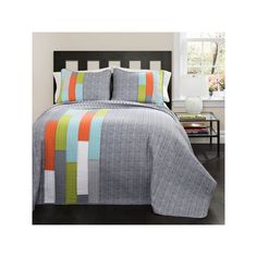 a bed with a gray and orange quilt on it