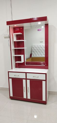 a red and white cabinet with a mirror above it