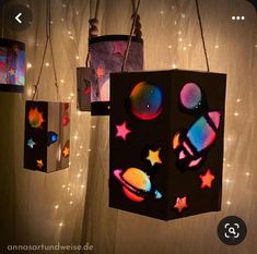 some lights are hanging from the ceiling and have different designs on them, including stars