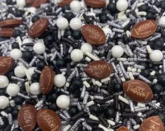 chocolate and white candies are scattered on top of black and white sprinkles