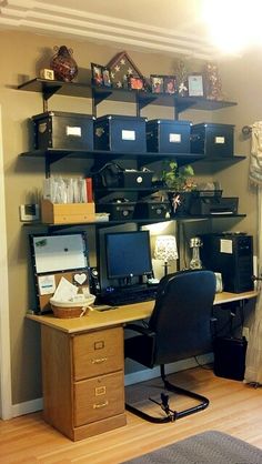 a desk with two computer monitors on top of it and some shelves above the desk