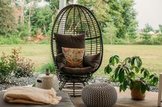 a chair and ottoman on a patio with trees in the background as well as a potted plant