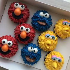 cupcakes decorated like sesame street characters are in a box with googly eyes