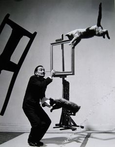 a man standing on top of a chair next to a person jumping up into the air