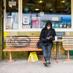 a person sitting on a bench in front of a store