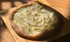 an uncooked pizza sitting on top of a wooden cutting board