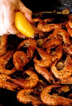 a person is cooking shrimp in a skillet