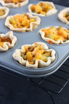 mini pies filled with different types of food on top of a baking sheet in an oven