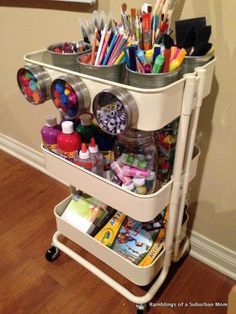 a cart filled with lots of crafting supplies on top of a hard wood floor