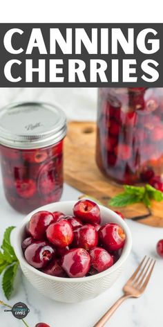 a bowl full of cherries sitting on top of a table next to a jar of canned cherries