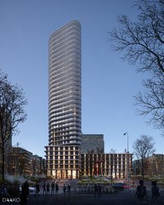 people are walking around in front of a tall building at dusk with the lights on