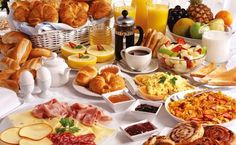 a table filled with lots of different types of breakfast foods and drinks on top of it