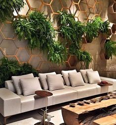 a living room filled with lots of furniture and greenery on the wall behind it