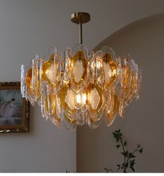 a chandelier hanging from the ceiling in a room with pictures on the wall