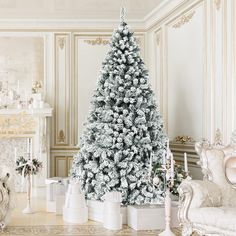 a white christmas tree sitting in the middle of a living room