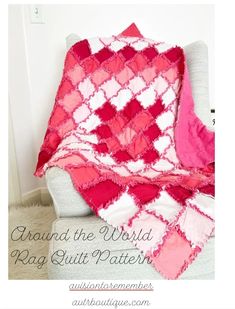 a pink and white blanket sitting on top of a couch next to a chair with a pillow