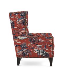 an upholstered arm chair with red and blue designs on the back, sitting in front of a white background