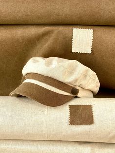 Classic and elegant natural linen sailor cap in beige with brown cotton canvas visor. Adorned with a ribbon of the same fabric as the visor and riveted with metallic buttons in old gold color. Cut and sewn on the bias with a quality linen fabric and finished with a very light cotton lining. The length of the visor is 4.5 centimeters. The back of the cap has a small eco-leather belt to adjust the measurement up to three centimeters less. It adapts very well to the head. For its production we use Cap Man, Captain Cap, Sailor Cap, Beige Hat, Linen Summer, Brown Hats, Summer Hat, Summer Hats, Linen Women