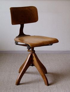 an old wooden chair sitting on top of a carpeted floor