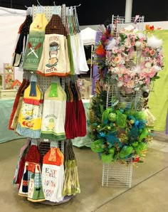 there are many different items on display at this market stall, including t - shirts and aprons