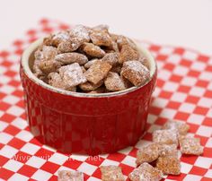 a red bowl filled with powdered sugar on top of a checkered table cloth