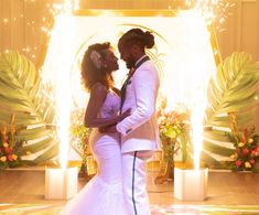 a bride and groom are standing in front of a backdrop with fireworks at their wedding