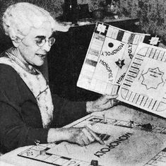 an older woman holding up a quilt with words written on it in black and white