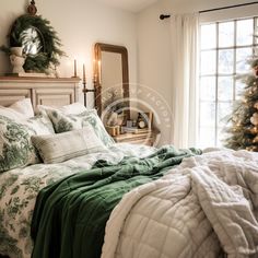 a bed with green and white comforter next to a christmas tree in front of a window