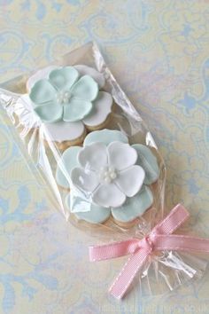 three decorated cookies in a package on a table